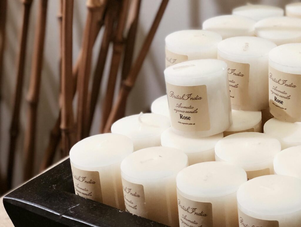 Close-up of elegant white candles displayed alongside bamboo sticks, creating a serene atmosphere indoors.