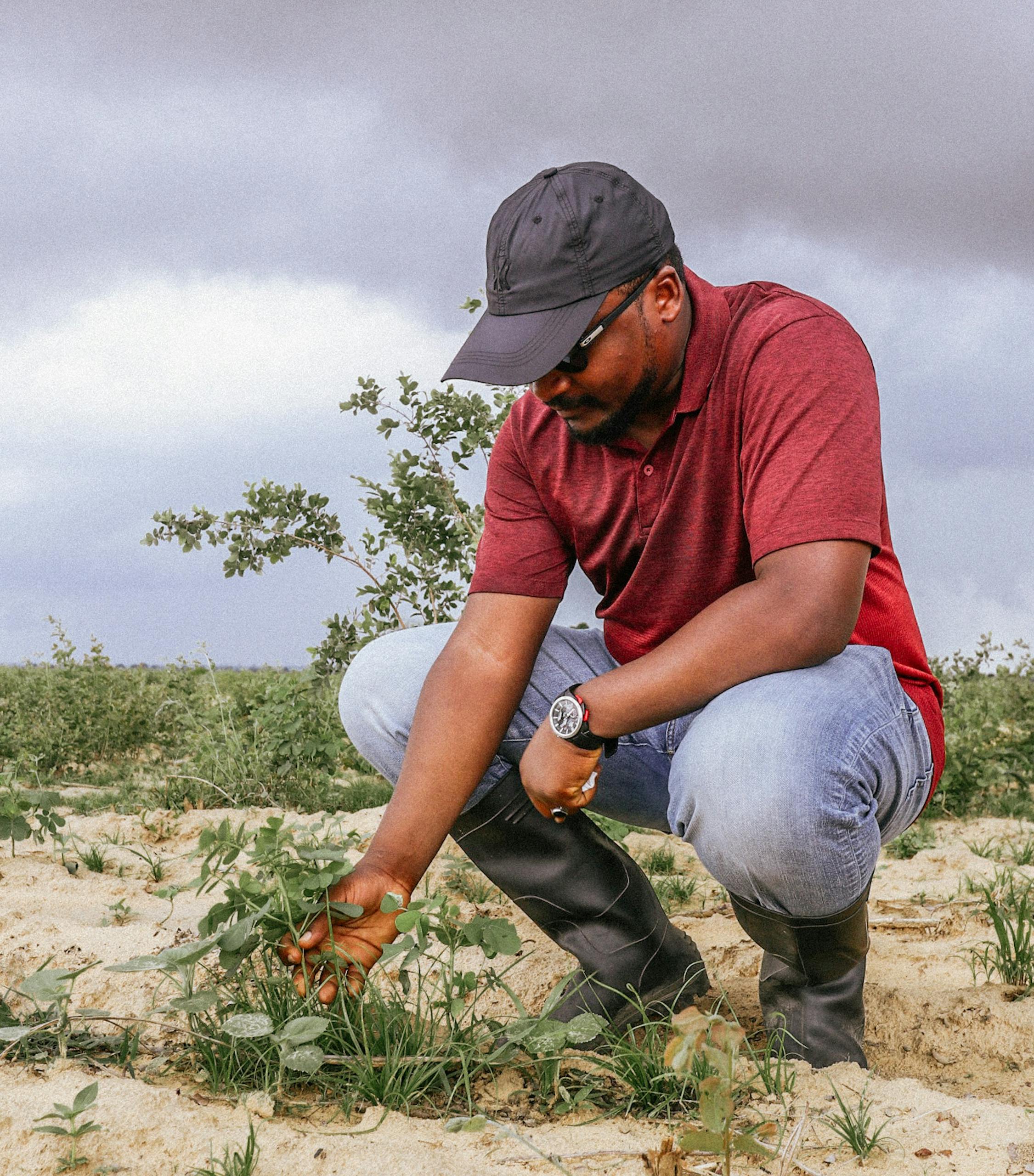 Getting hands in the soil 🌿! This guy vibing with nature, checking out some plants in the sandy terrain. Overcast skies but the green's still popping 😊